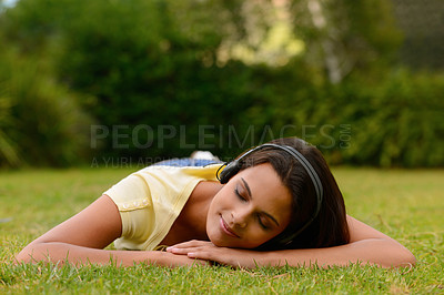Buy stock photo Sleeping, girl and headphones music in park for relaxation, peace and calm meditation in India. Wellness, happy and Indian woman resting on green grass while streaming audio in nature with smile.