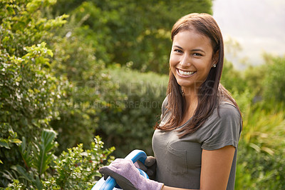 Buy stock photo Shot of an attractive young woman watering her garden