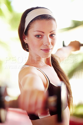 Buy stock photo Shot of an attractive young woman working out with dumbells