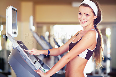 Buy stock photo An attractive young woman using a step machine in the gym