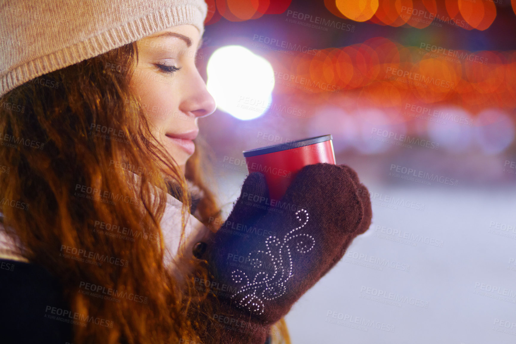 Buy stock photo Shot of a beautiful young woman enjoying a warm beverage outdoors