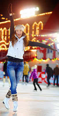 Buy stock photo Shot of a beautiful young woman skating on an ice rink at night