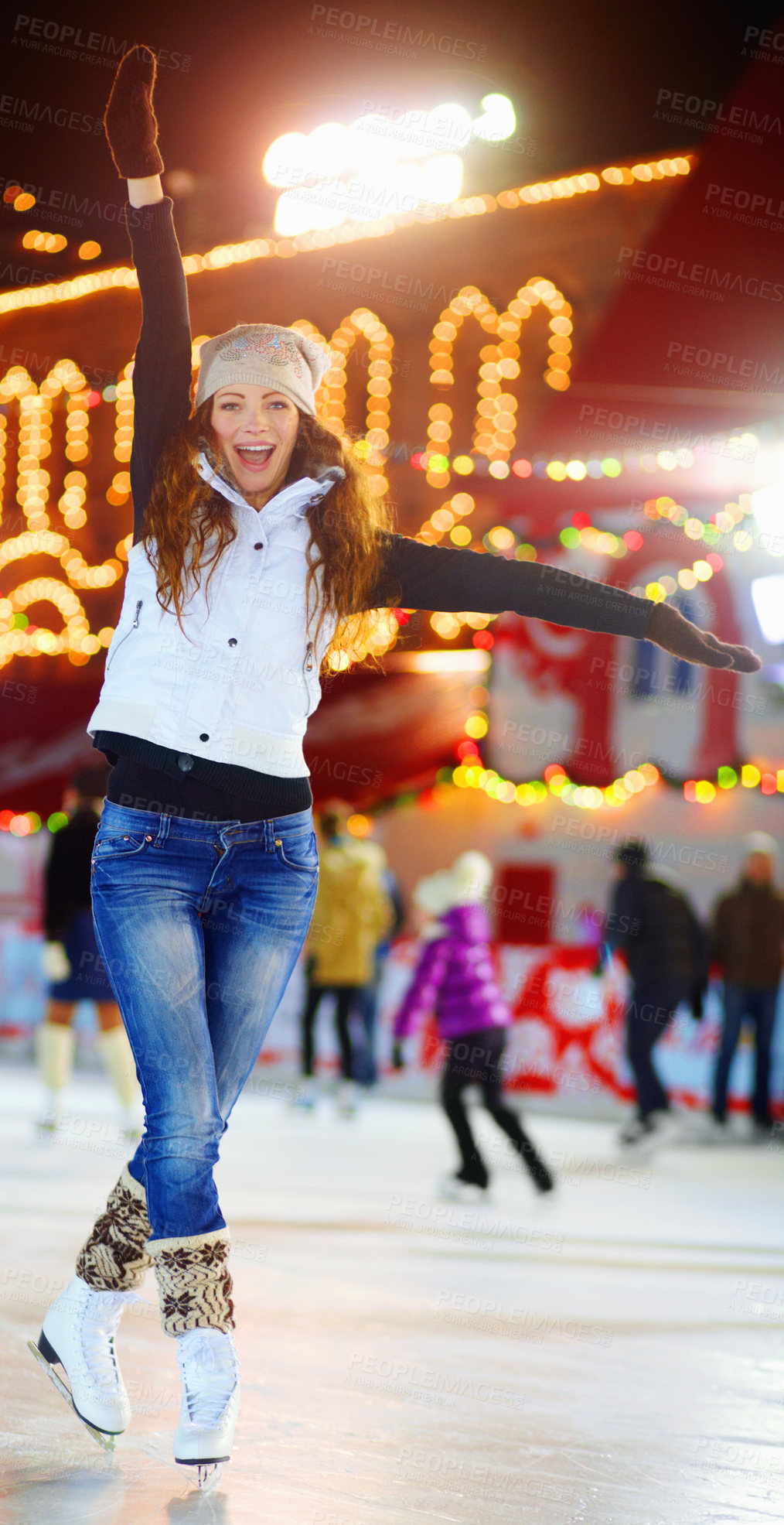 Buy stock photo Shot of a beautiful young woman skating on an ice rink at night