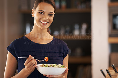 Buy stock photo A beautiful young woman eating a bowl of salad at home