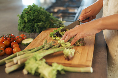 Buy stock photo Shot of a woman cutting up vegetables on a chopping boards