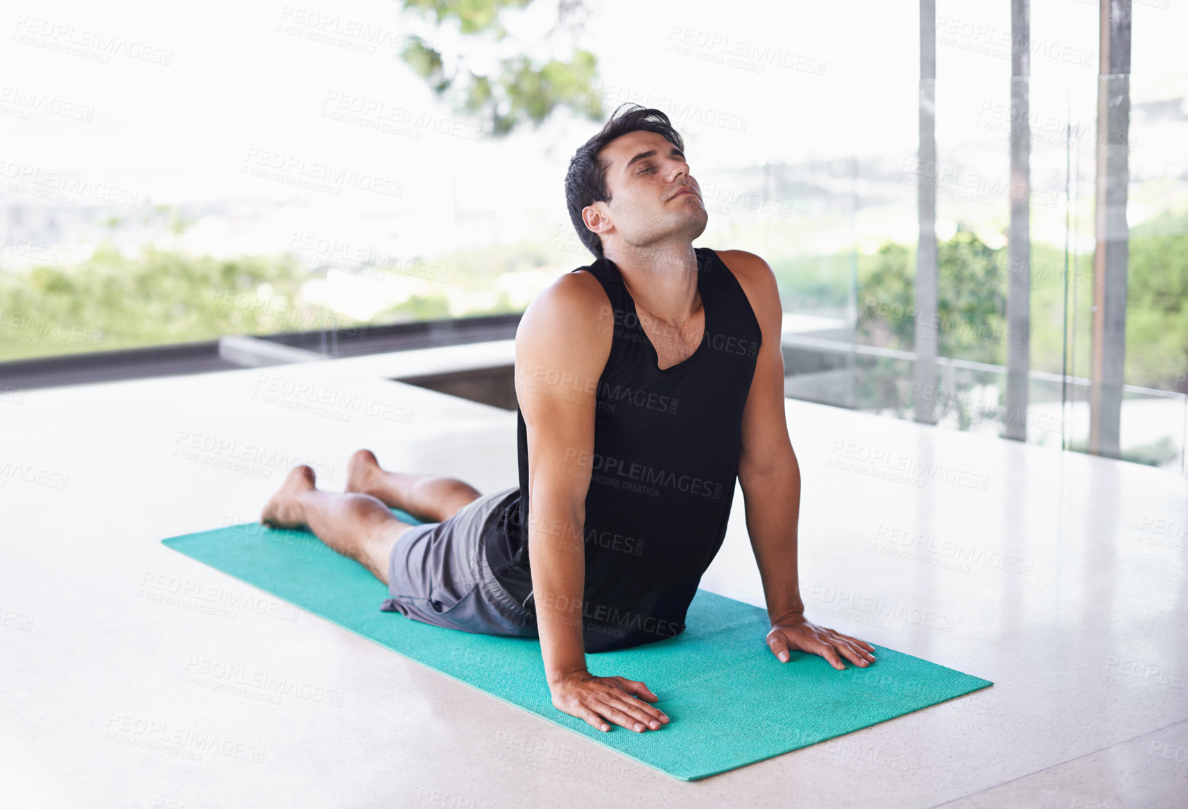 Buy stock photo A content young man doing yoga at home