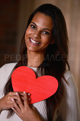 Buy stock photo Portrait of an attractive ethnic female holding a heart shaped card indoors