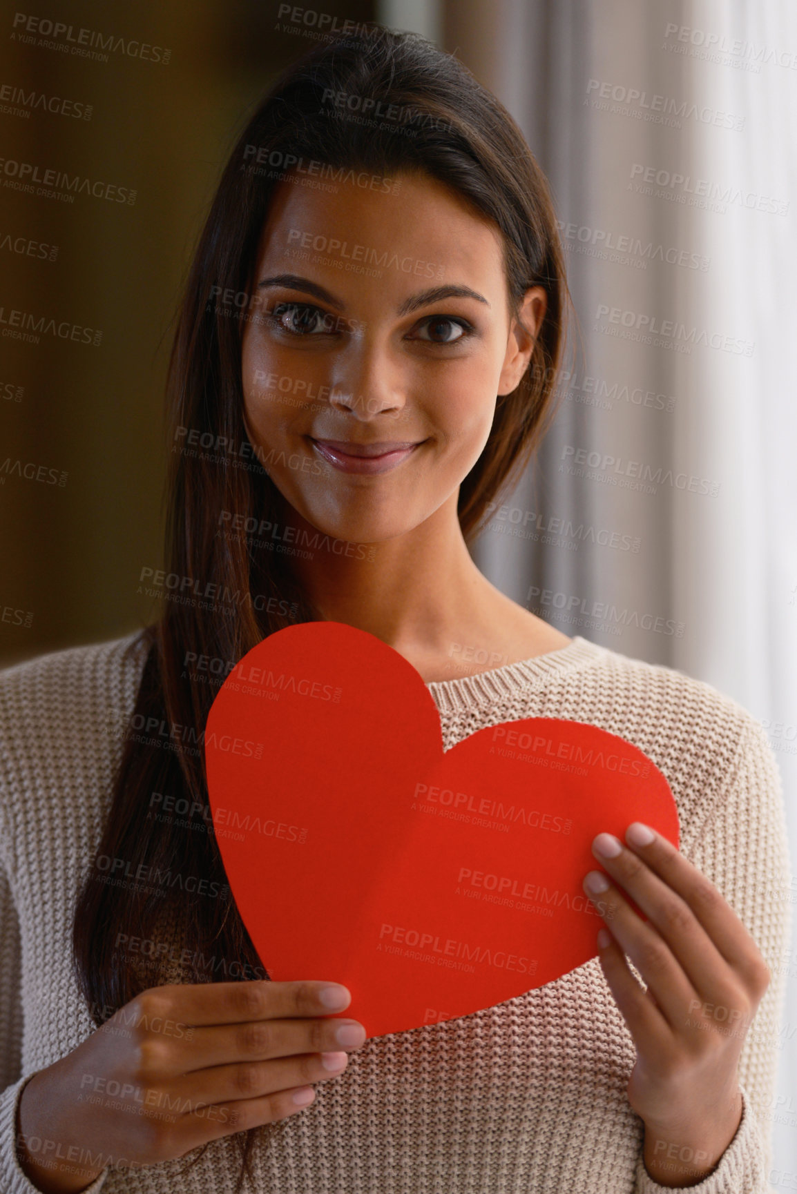 Buy stock photo Woman, face and red heart paper in house or home for valentines day, cardiology surgery organ donor or support. Portrait, smile or happy Indian person with love cut out for trust, comfort or kindness