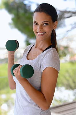 Buy stock photo Portrait of a beautiful woman lifting dumbbells by a window