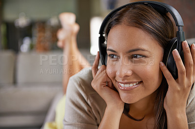 Buy stock photo Shot of an attractive young woman listening to music through her headphones