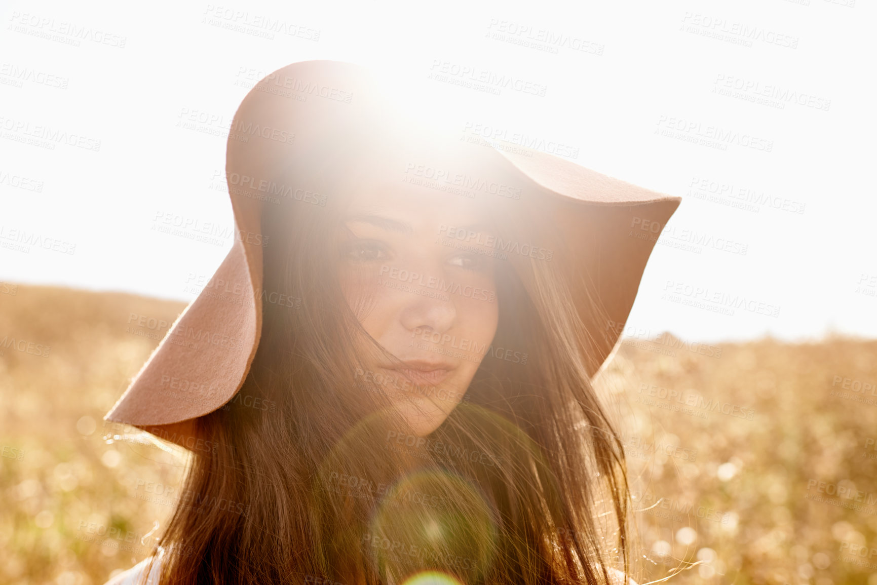 Buy stock photo Woman, sunshine and wheat field with hat for summer, holiday or outdoor weekend in nature. Face of female person or teenager with lens flare in the countryside for adventure, travel or fresh air