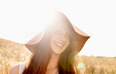 Buy stock photo Wheat, field and woman with smile in sunlight for travel, fresh air and summer holiday with lens flare and hat. Person, face or happiness in meadow countryside with confidence and pride in nature 