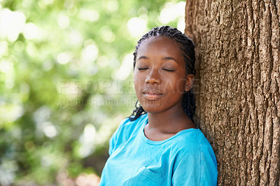 Buy stock photo Teen, girl and relax by tree bark outdoors, rest and peace in woods or forest on summer holiday. Black female person, nature and face in park or garden, calm and wellness on travel to Nigeria
