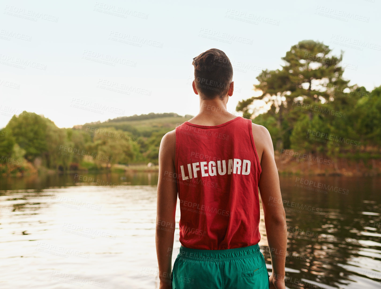Buy stock photo Back view, landscape and lifeguard outdoor at lake, river and working for safety, security and health of people swimming. Young man, male person and youth in nature, forest and environment with water