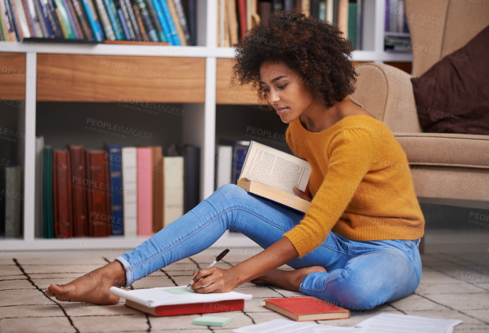 Buy stock photo Cropped shot of an attractive young woman sitting on the floor while studying