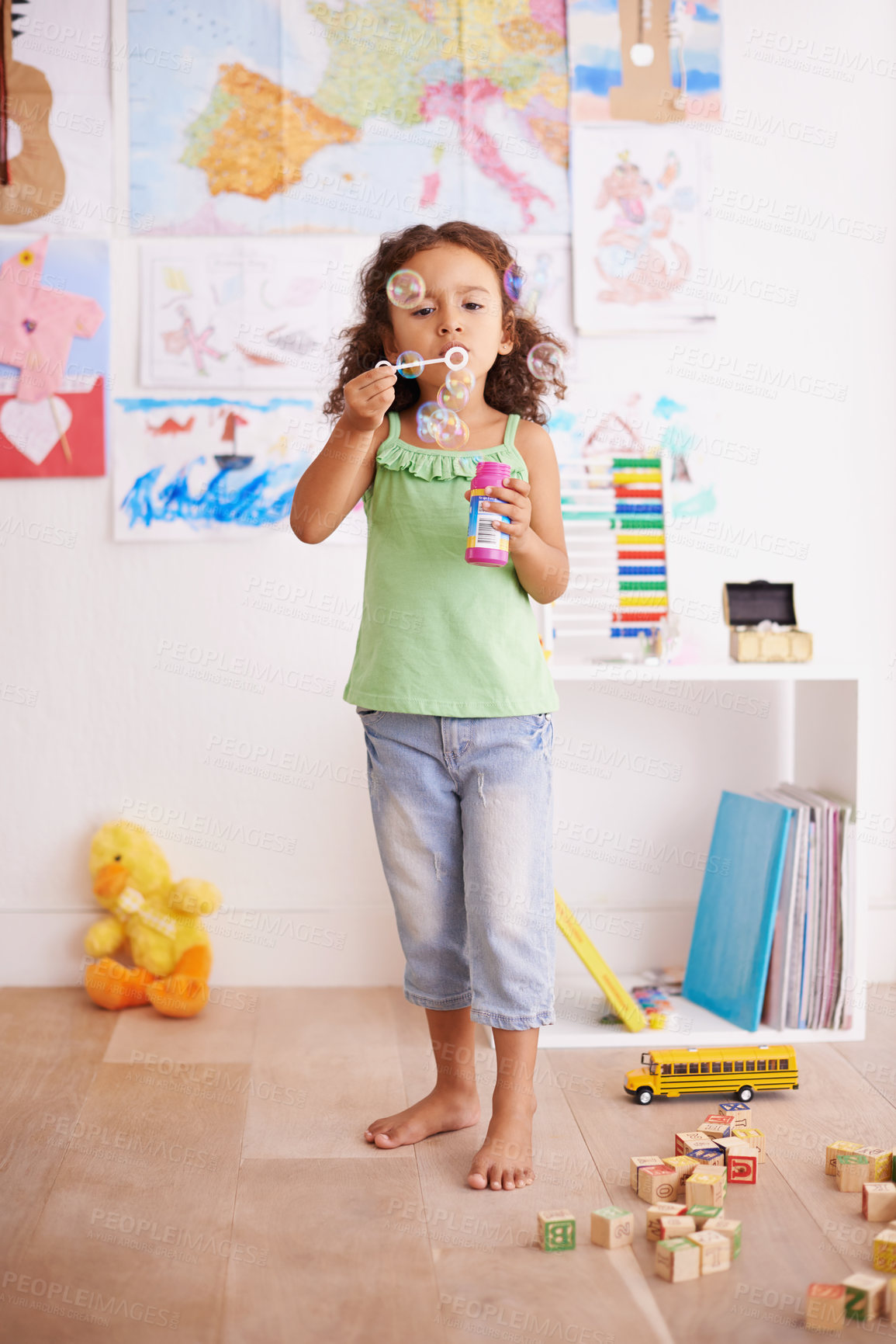 Buy stock photo Kid, toy and blowing bubbles for childhood development, playing and having fun alone in room. Happy, growth and face of young girl in kindergarten for learning, soap bubble wand and activity games