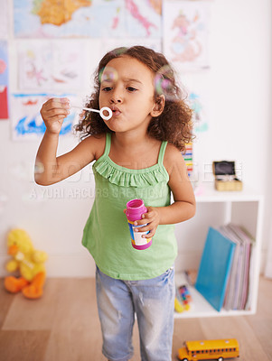 Buy stock photo Girl, toy and blowing bubbles for development, playing and having fun alone in room. Happiness, growth and face of young child in kindergarten for learning, soap bubble wand and activity games