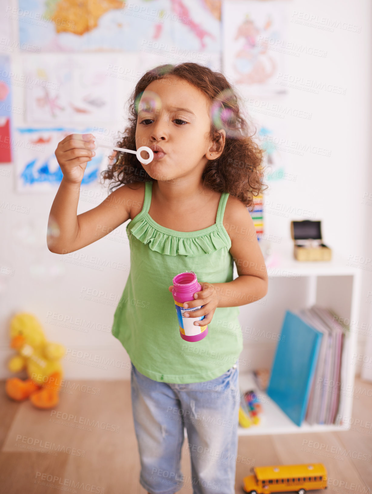 Buy stock photo Girl, toy and blowing bubbles for development, playing and having fun alone in room. Happiness, growth and face of young child in kindergarten for learning, soap bubble wand and activity games