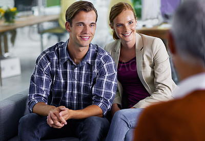 Buy stock photo Smiling young couple receiving positive advice from their financial consultant