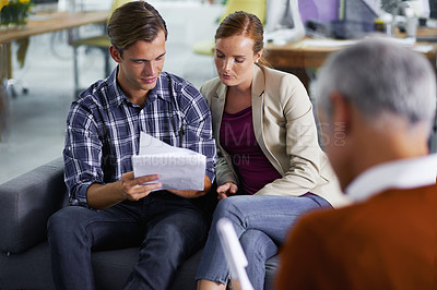 Buy stock photo Smiling young couple receiving positive advice from their financial consultant
