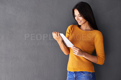 Buy stock photo Woman, fashion and smile for tablet, mockup and grey background in beauty with style and wall. Female person, space and casual look for confidence, tech and attractive for happiness and social media