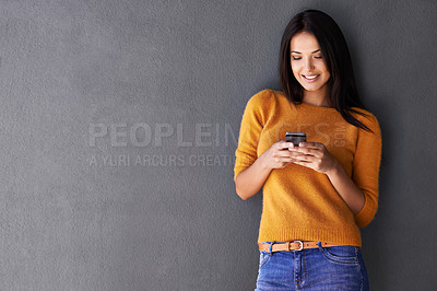 Buy stock photo Woman, phone and app for communication in studio, online and blog or reading notification. Female person, smile and scroll or browse on social media, gray background and internet for networking