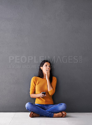 Buy stock photo Bored, tired or woman with phone yawn on floor for social media, scroll or web search on wall background. Fatigue, burnout or female person with smartphone app on the ground sleepy from reading ebook