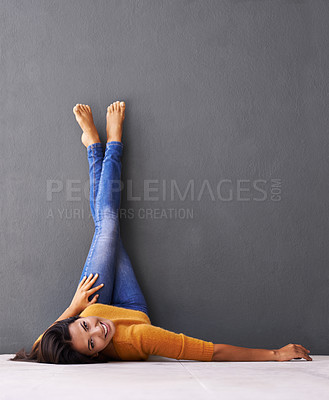 Buy stock photo Woman, smile and wall background, trendy, clothes on wall and relaxing on floor in portrait with fashion. Female person, happy and chill at home for happiness and wellness in jeans upside down