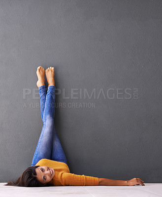 Buy stock photo Portrait, floor and happy woman relax with casual style on a grey wall background for rest. Leisure, style and face of smiling female person upside down on a dark studio backdrop for fashion