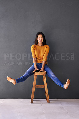 Buy stock photo Portrait, fashion and woman on chair in studio for excited, trendy or casual clothing with gray background. Happiness, cheerful and face of person on stool for wardrobe, sweater and stylish outfit