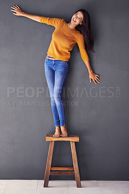 Buy stock photo Portrait, smile and chair with woman in studio for fashion, casual and confident style. Happiness, trendy and funny with young female person laughing on gray background for mockup space and joy