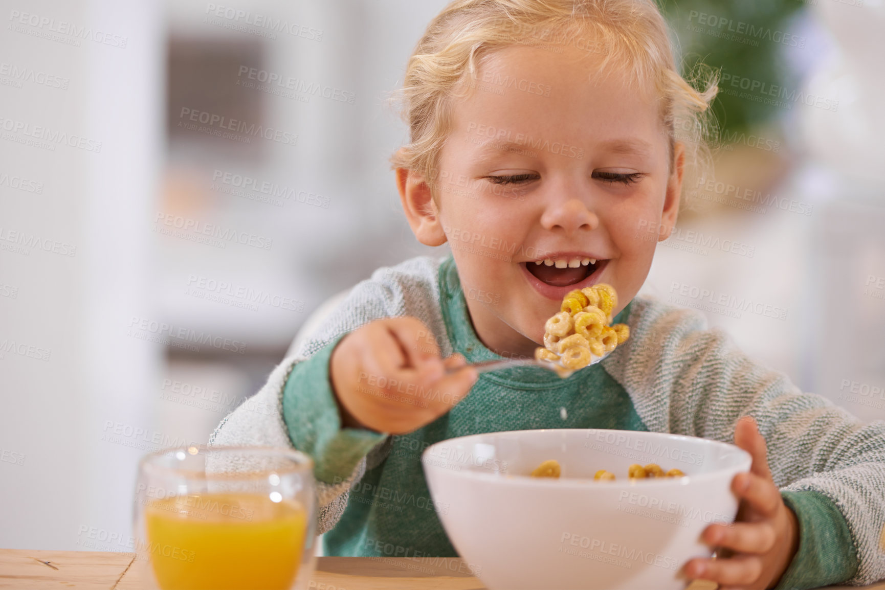 Buy stock photo Morning, breakfast and cereal with child or table, Happy girl and home eating for nutrition. Energy and glass with orange juice for vitamins, fibre for toddler and healthy development for growing kid