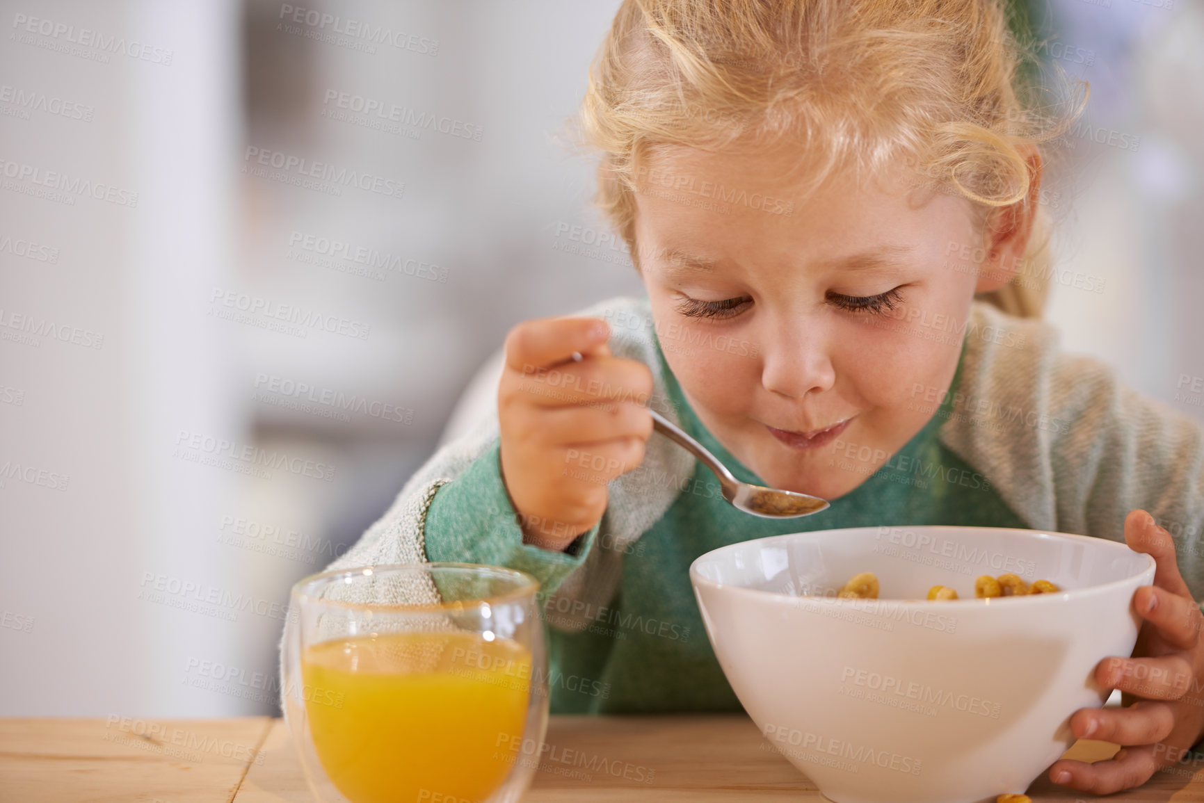 Buy stock photo Home, eating and cereal with girl or child, happy morning and nutrition with table. Breakfast, glass or orange juice for vitamins, fibre for toddler and healthy development of growing kid in house