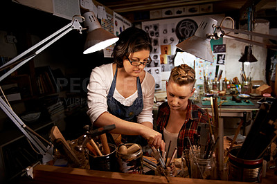 Buy stock photo Women, craft and tools in workbench for creative design, wood sculpture or handmade project at night. Artist, collaboration and manufacturing in studio with teamwork, assistance and workshop skills