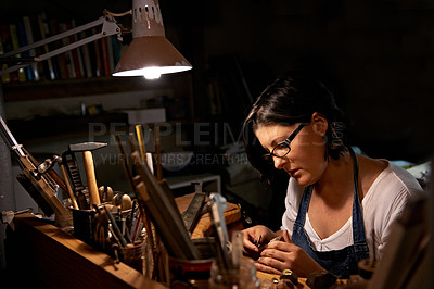 Buy stock photo Wood, carving and artist in workshop with creative project or unique sculpture on table at night. Artisan, carpenter and woman with talent for creativity in dark studio in process of woodworking