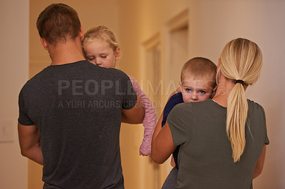 Buy stock photo Shot of young parents carrying their sleepy children to bed