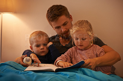 Buy stock photo A father reading a bedtime story to his kids