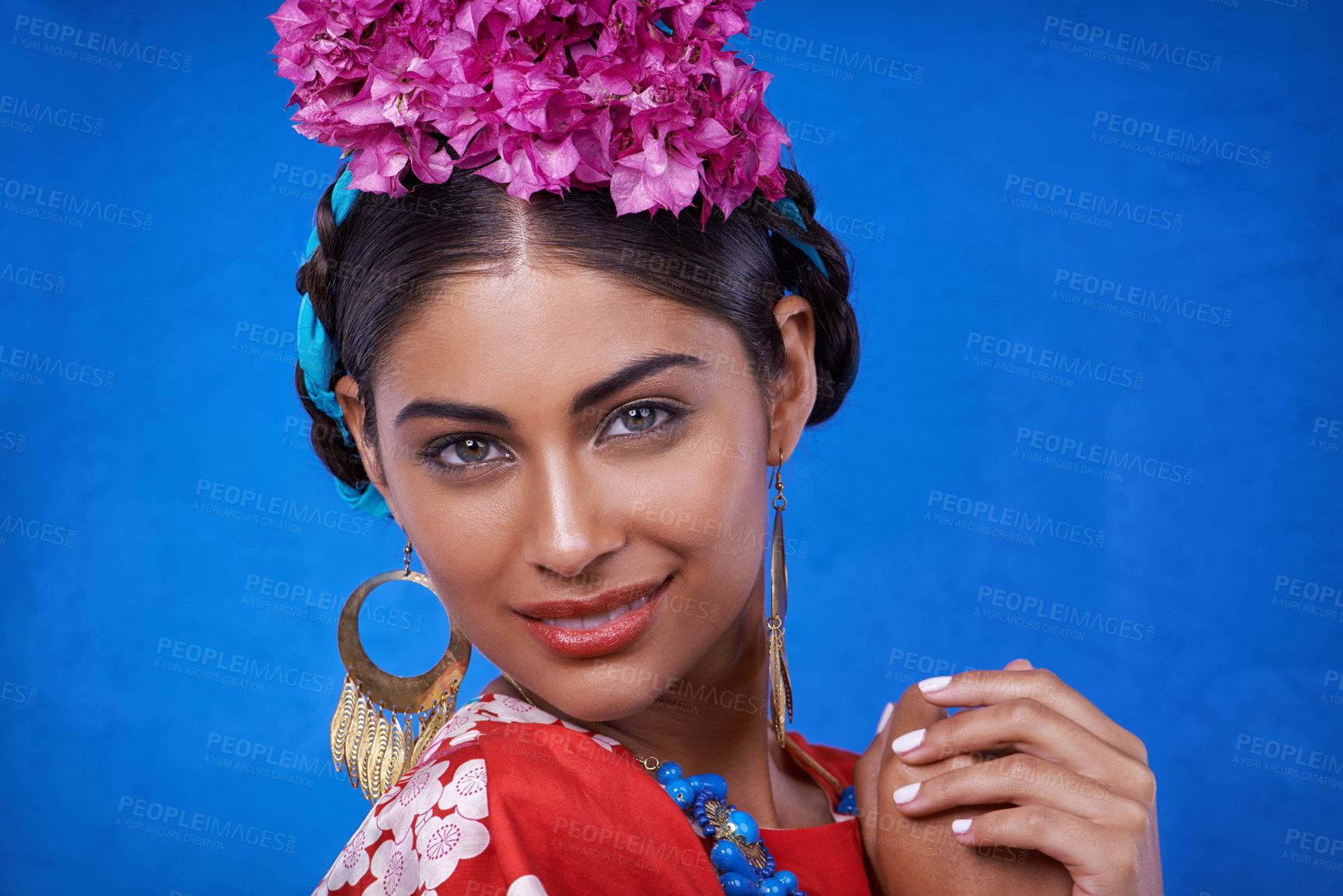 Buy stock photo Portrait, beauty and happy woman with flowers in hair isolated on blue studio background in India. Face, smile or person with floral cosmetics, natural or organic makeup on skin with leaf for fashion