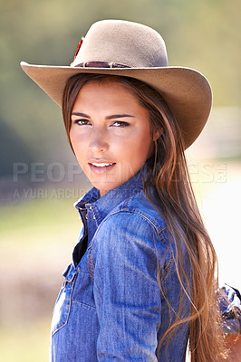Buy stock photo Portrait of an attractive young cowgirl standing in the sun