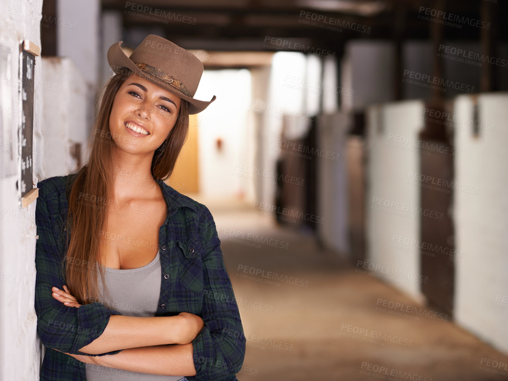 Buy stock photo Portrait, smile and arms crossed with cowgirl in barn of farm for agriculture, equestrian or sustainability. Countryside, rural or western with happy young person at ranch in countryside for farming