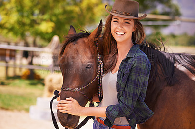Buy stock photo Portrait of a young cowgirl standing outside with her horse