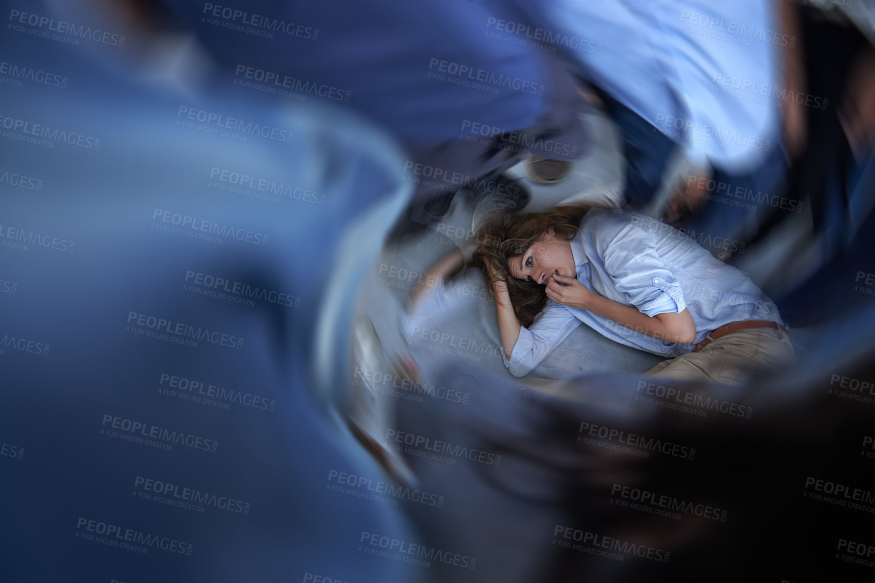 Buy stock photo Shot of a young woman curled up on the floor in a panic state