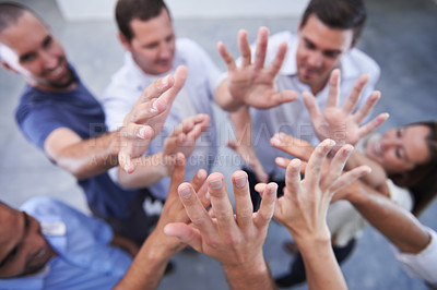 Buy stock photo Shot of a group of coworkers raising their hands together