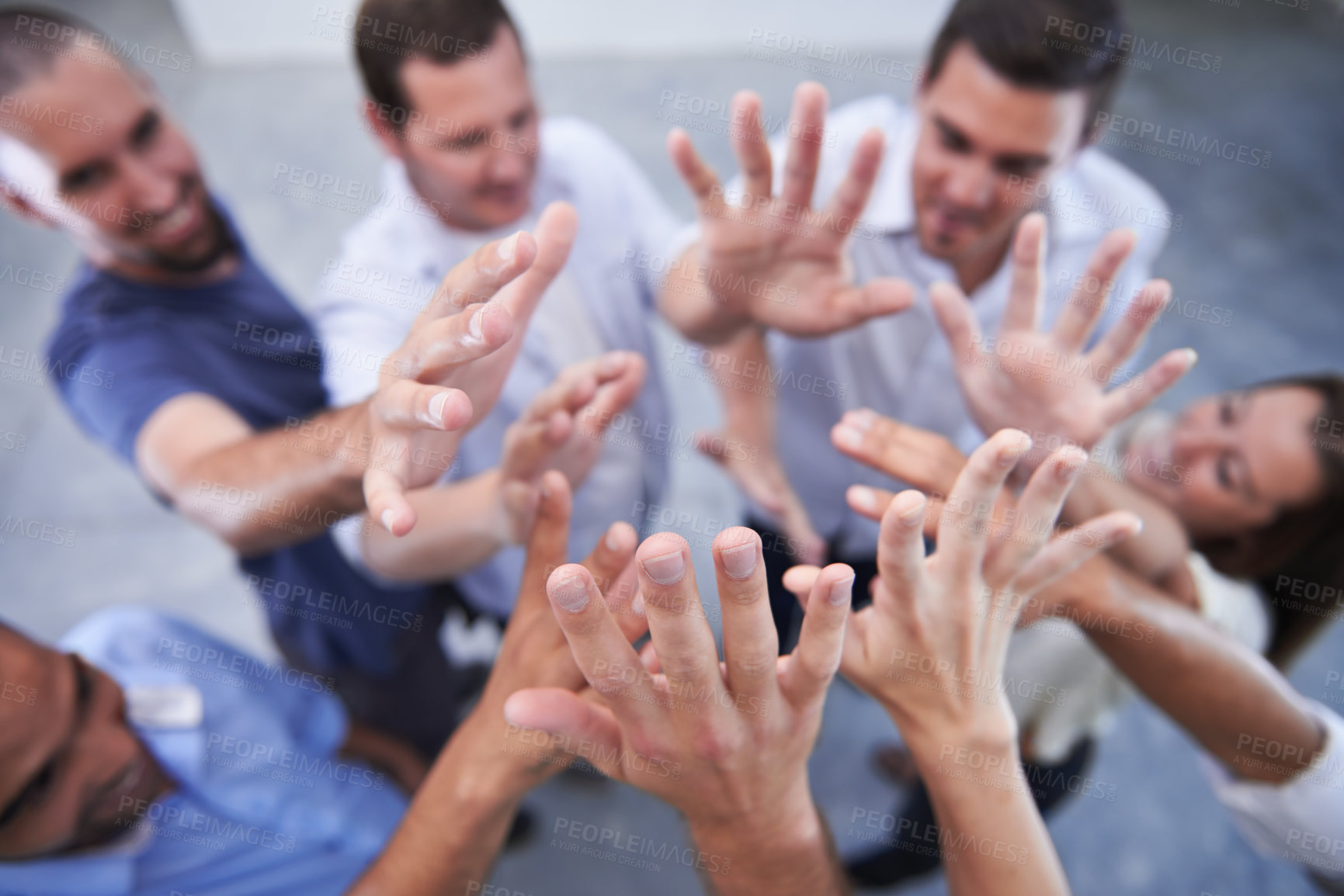 Buy stock photo Shot of a group of coworkers raising their hands together