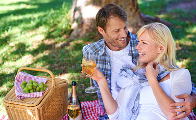 Buy stock photo Couple, picnic and relax in park with champagne for bonding connection on holiday for celebration, summer or trip. Man, woman and drinking in nature with basket or fruit for love, date or happiness