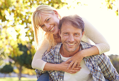 Buy stock photo Shot of a happy man piggybacking his wife