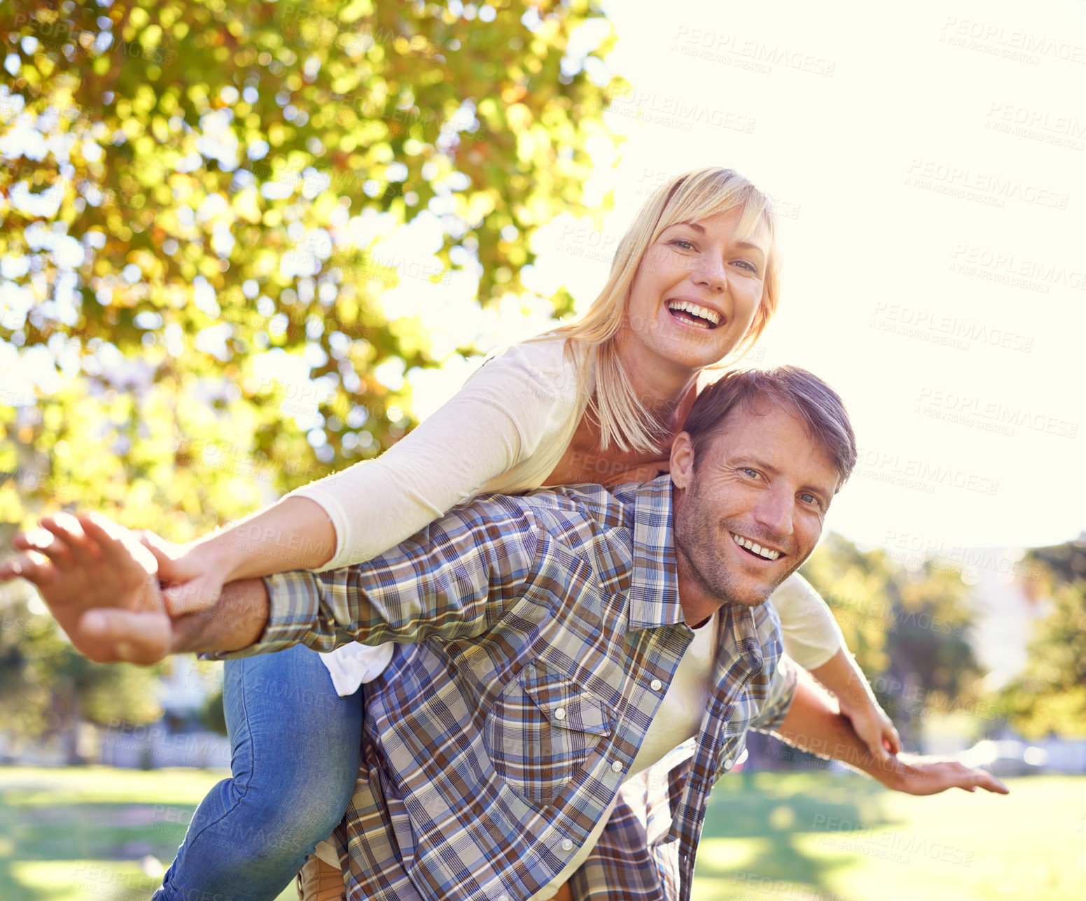 Buy stock photo Shot of a happy man piggybacking his wife