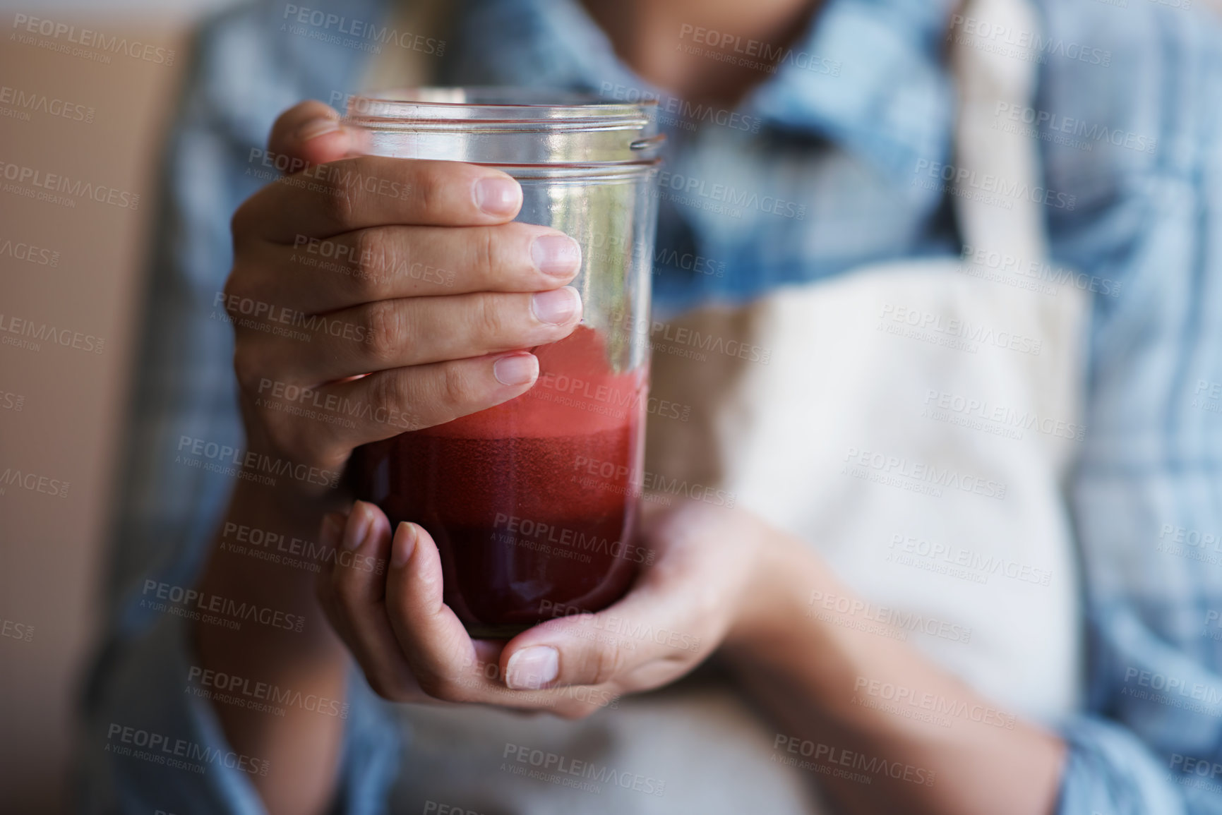 Buy stock photo Hands, glass and juice with kitchen, closeup and person with smoothie for health and wellness. Chef, drink and beverage for nutrition, vitamins and vitality for juicing diet with apron at home