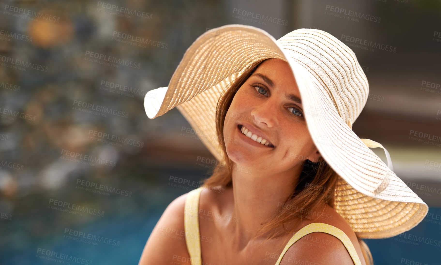Buy stock photo Fashion, portrait and happy woman relax at pool with hat in summer, holiday or vacation in California. Girl, smile and sitting outdoor on deck in sunshine with casual style for backyard or garden