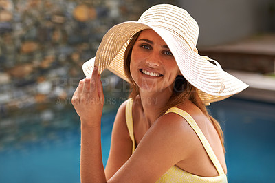Buy stock photo Fashion, portrait and happy woman relax at pool with hat in summer, holiday or vacation in California. Girl, smile and sitting outdoor on deck in sunshine with casual style at hotel or villa